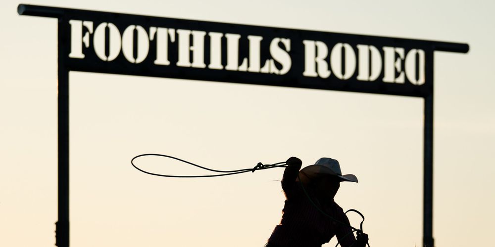 Backlit breakaway roper competing at an amateur event