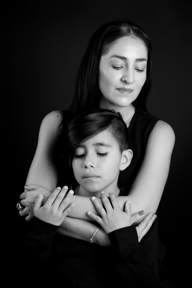 Retrato artístico de madre e hijo en blanco y negro con iluminación dramática de estudio. Fotografía familiar de autor premium en Coyoacán