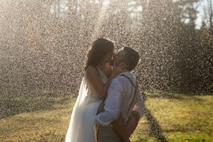 Bride and groom sharing a romantic kiss in a sparkling water spray rain session in Westerly Rhode Island.