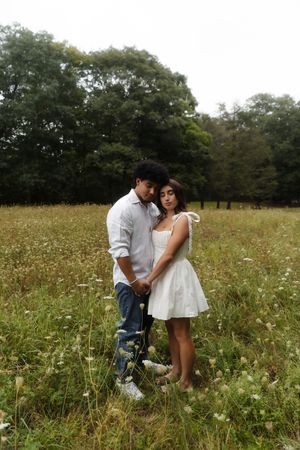 A couple stands embracing in a wildflower meadow, woman in white dress, Flower field located in Connecticut