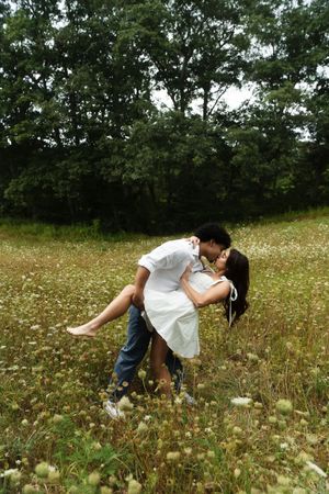 A romantic couple sharing a passionate kiss in a blooming meadow Flower field located in Connecticut