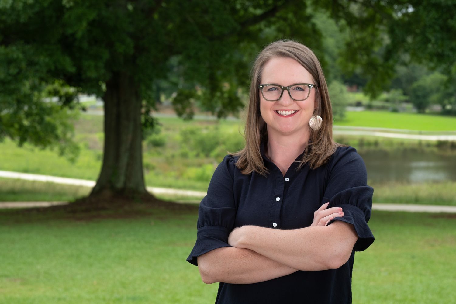 Professional Headshot Session with a business owner wearing glasses with her arms crossed in an outdoor headshot session.