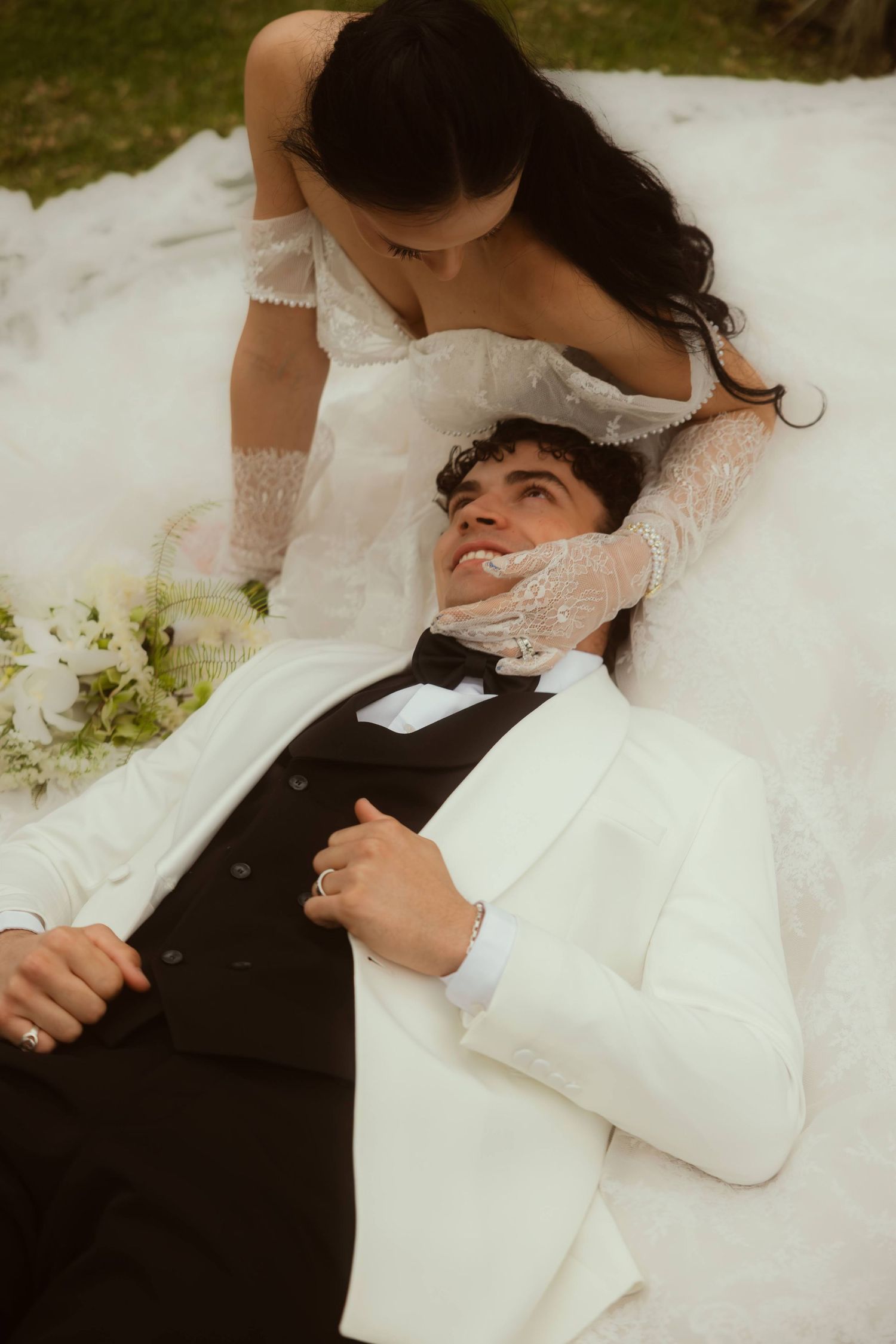 Elegant bride in lace off-shoulder gown beside groom in white tuxedo at their Ojai elopement.