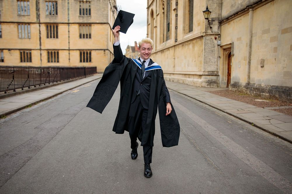Academic procession along historic stone buildings and streets.
