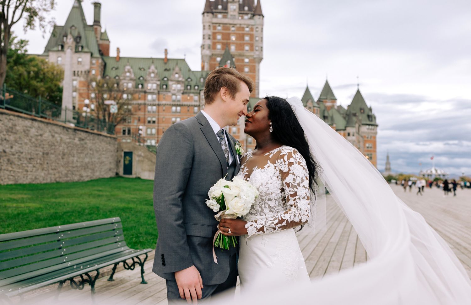 A couple embraces in front of the historic Chateau Frontenac hotel in Quebec City.