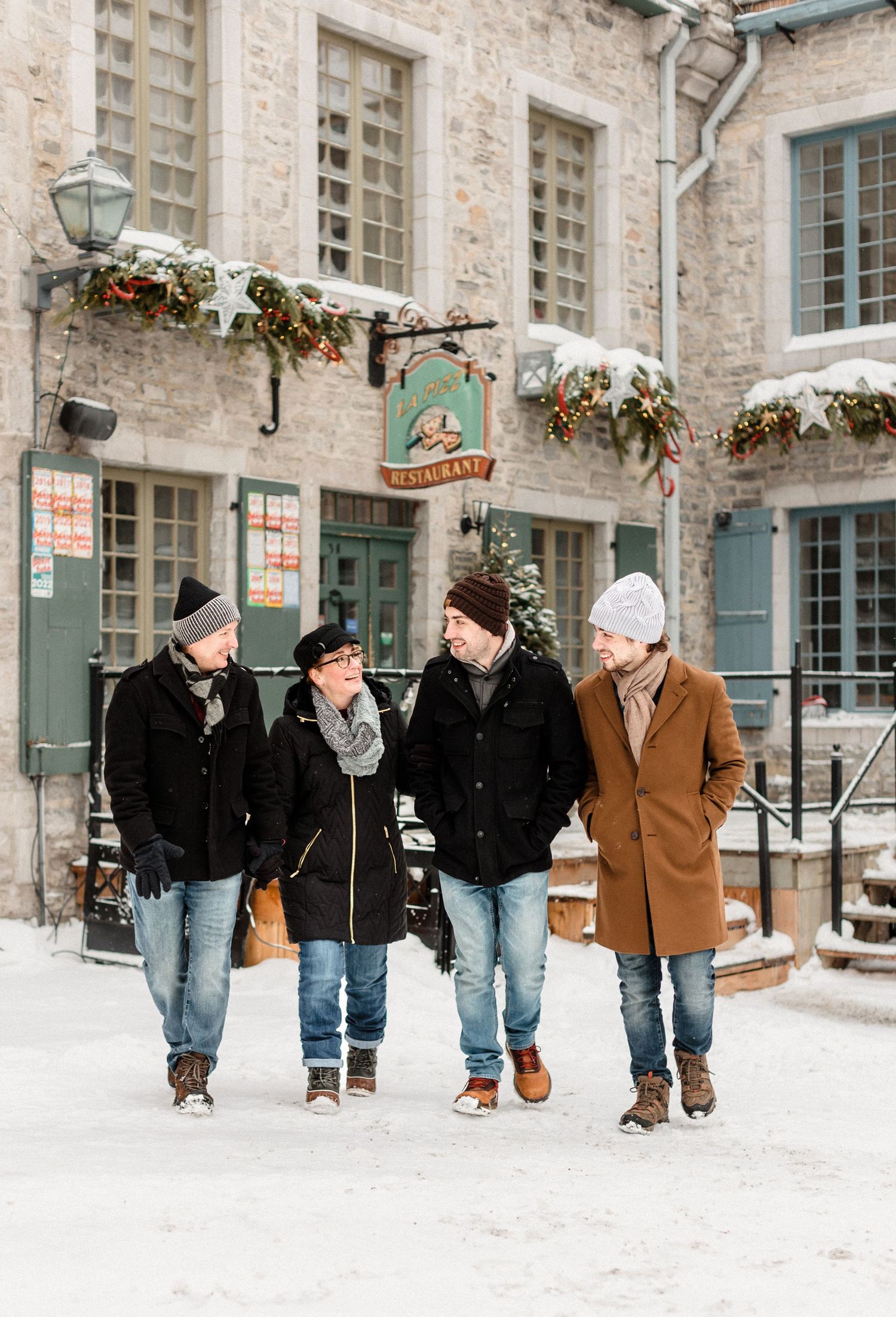 Group walking together through snowy Quebec City streets lined with historic architecture.