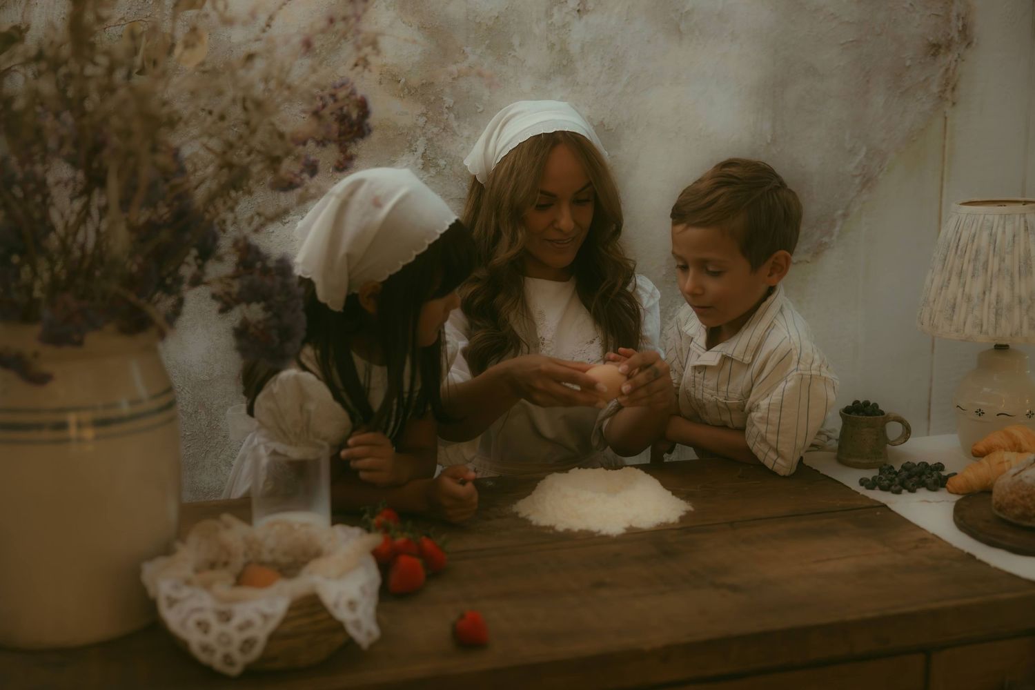 Woman and kids baking together at table with flour and strawberries in vintage kitchen setting shows an example of storytelling photography.