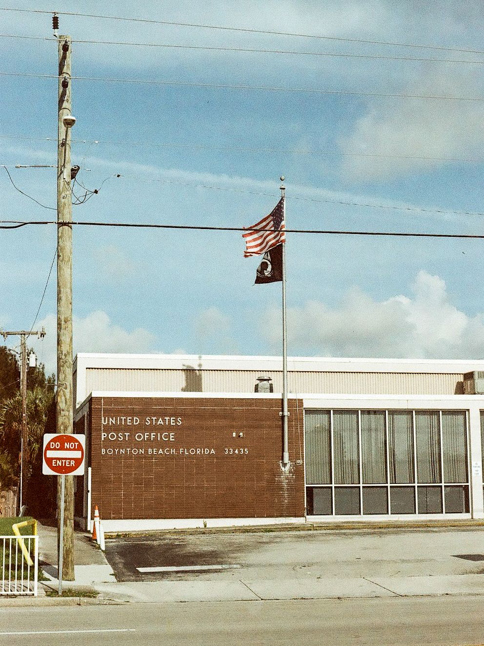 United States Post Office in Boynton Beach, Florida 33435 with American and POW flags flying outside.