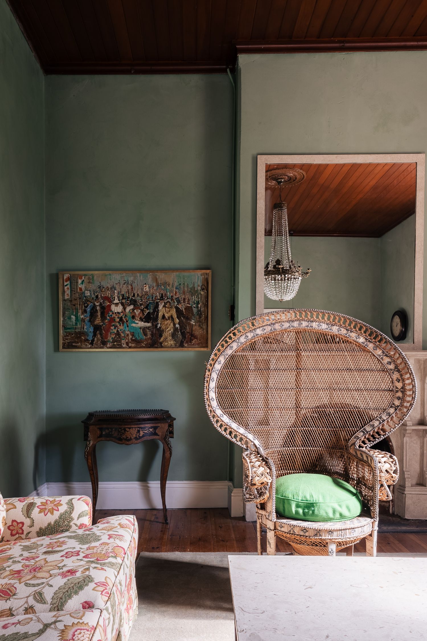 Vintage green-walled living room with wicker peacock chair, floral sofa, and ornate artwork.

Lime Au Lait Atelier
