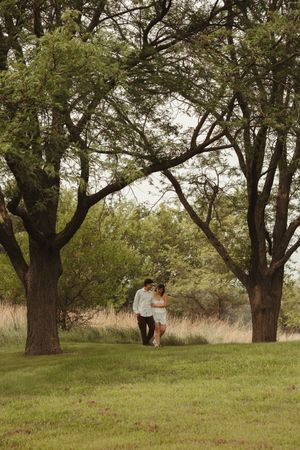 Couples photos of a woman in a white dress and a man in a white shirt with natural greenery and romantic emotion.