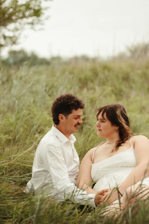 Natural light couples photography capturing a young couple in love with whimsical styling and green outdoor backdrop.