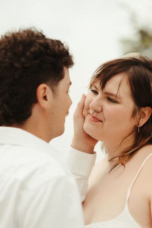 Couples photos in Brookings SD featuring a woman in a white dress and a man in a white shirt with an intimate, edgy, film-inspired style.