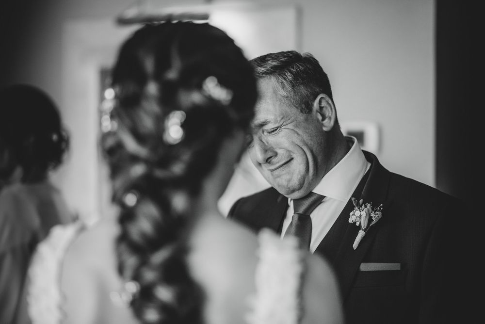 Padre emocionado al ver a su hija vestida de novia durante los preparativos de una boda en Asturias.