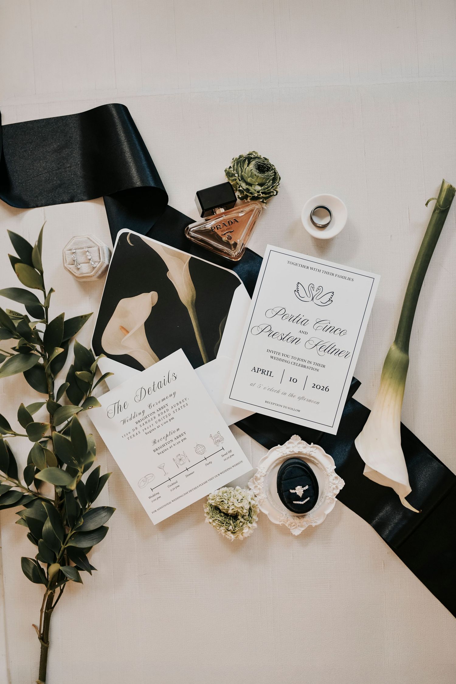 Luxury wedding flat lay with invitations, diamond jewelry, and satin ribbon