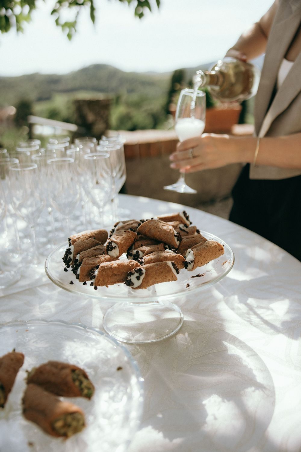 Plate of chocolate cookies displayed on white tablecloth in outdoor setting.