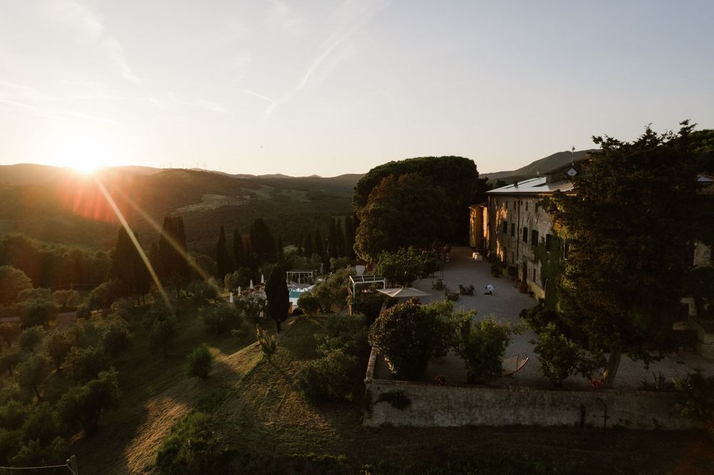 Sunset view over mountains and buildings with string lights creating a warm ambiance.