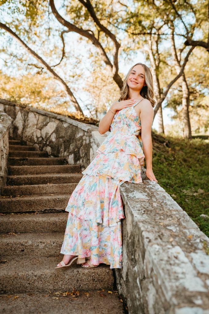 Portrait series on rustic stone steps featuring a floral summer dress in warm afternoon light.