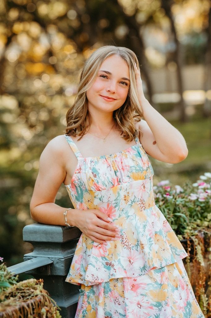 A dreamy summer portrait session featuring a pastel floral dress in a garden setting with warm bokeh lighting.