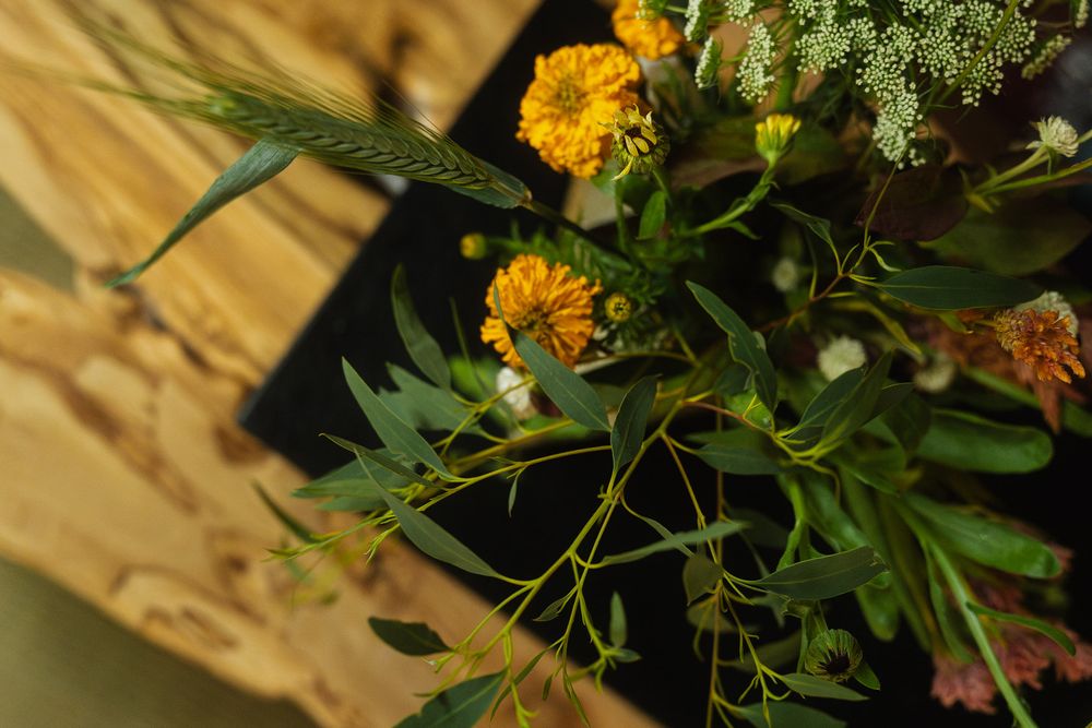 Candid shot of a woman walking through her open, light-filled home with flowers.