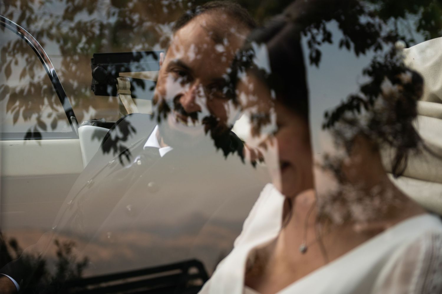 Romantic wedding couple dances together at sunset in a dreamy outdoor setting.