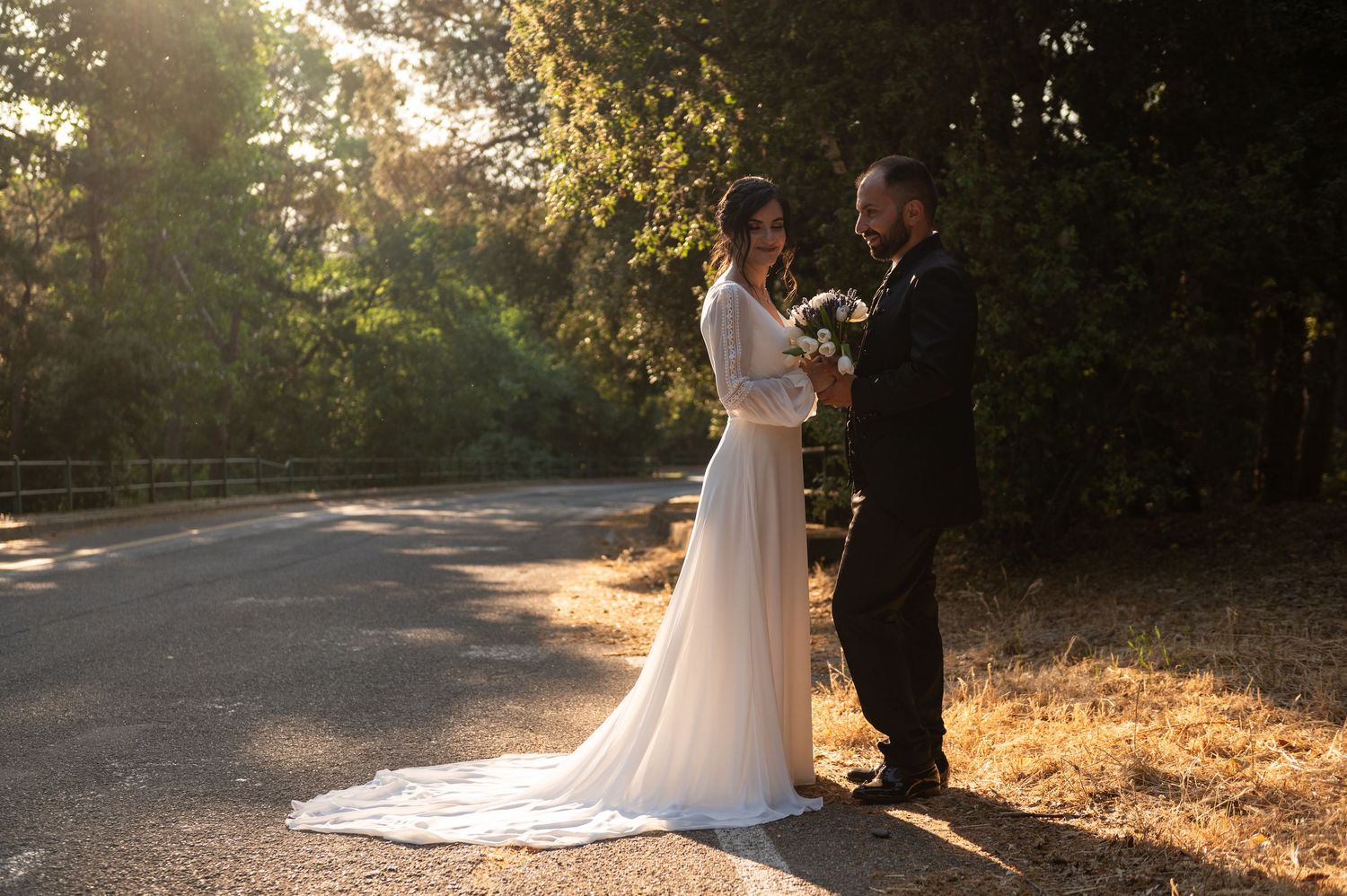 Newlyweds share an intimate moment during golden hour photography session outdoors.