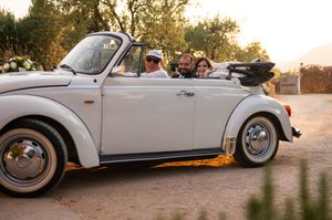 Classic white vintage car parked in scenic outdoor location at golden hour.