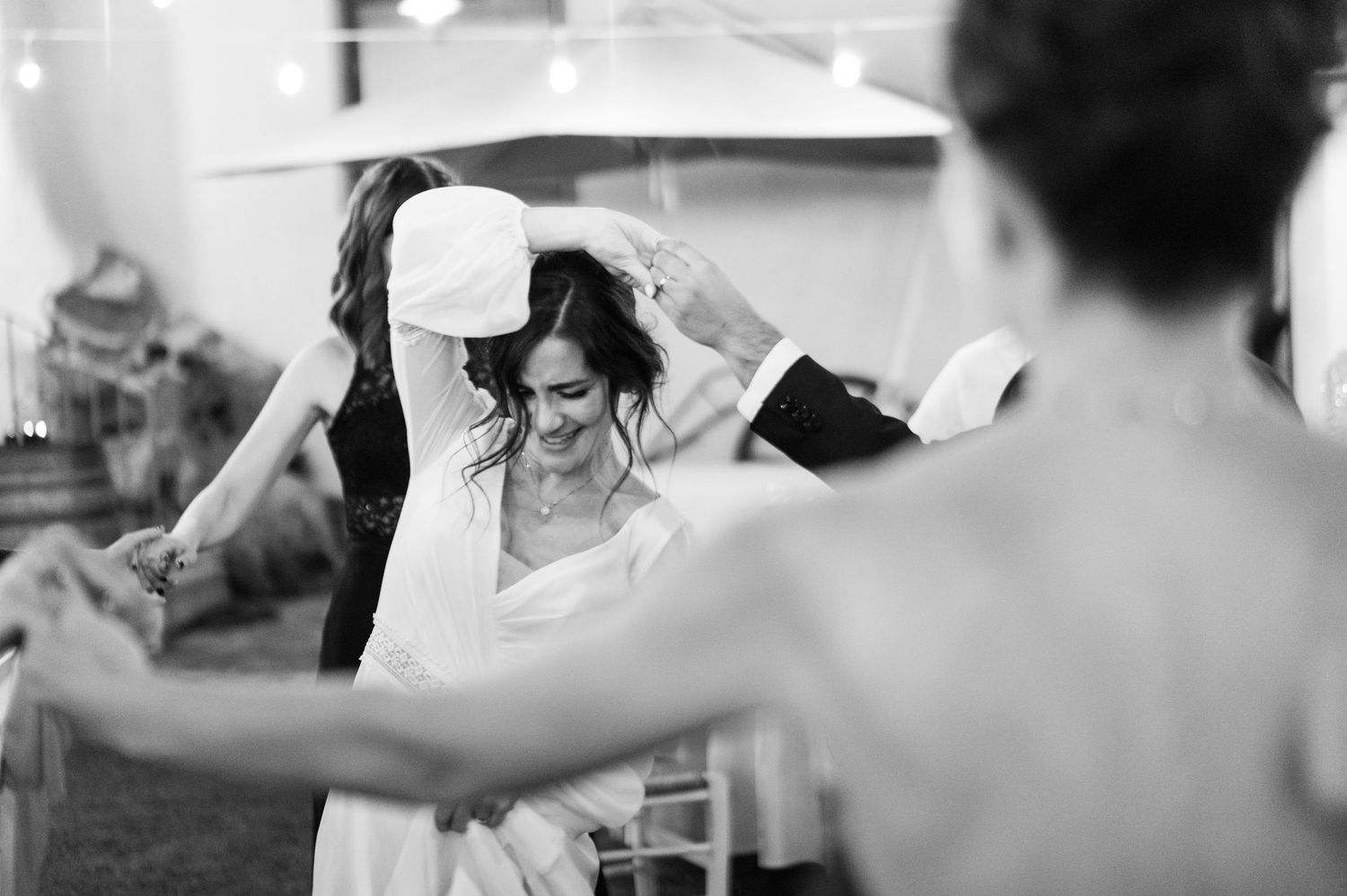 Wedding guests dancing and celebrating on an outdoor dance floor.