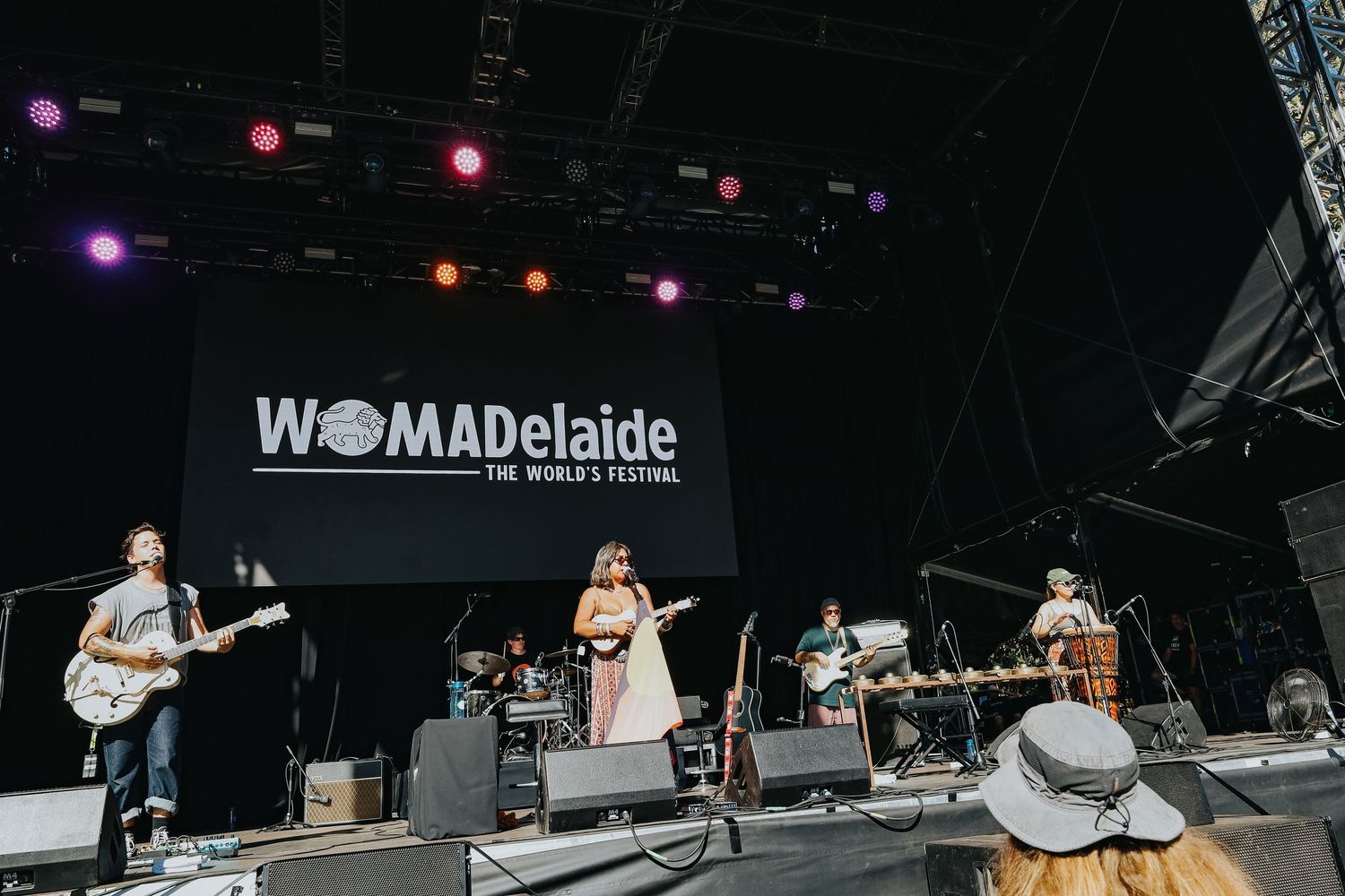Band performing on main stage at WOMADelaide The Worlds Festival in bright daylight.