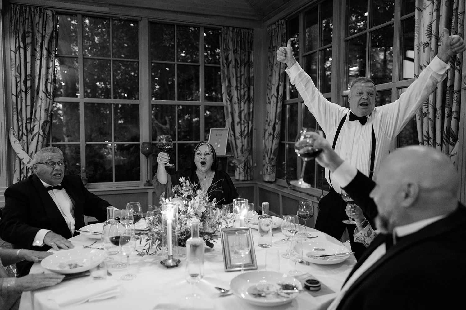 Elegant black and white wedding reception with guests seated at round tables in a formal dining room.