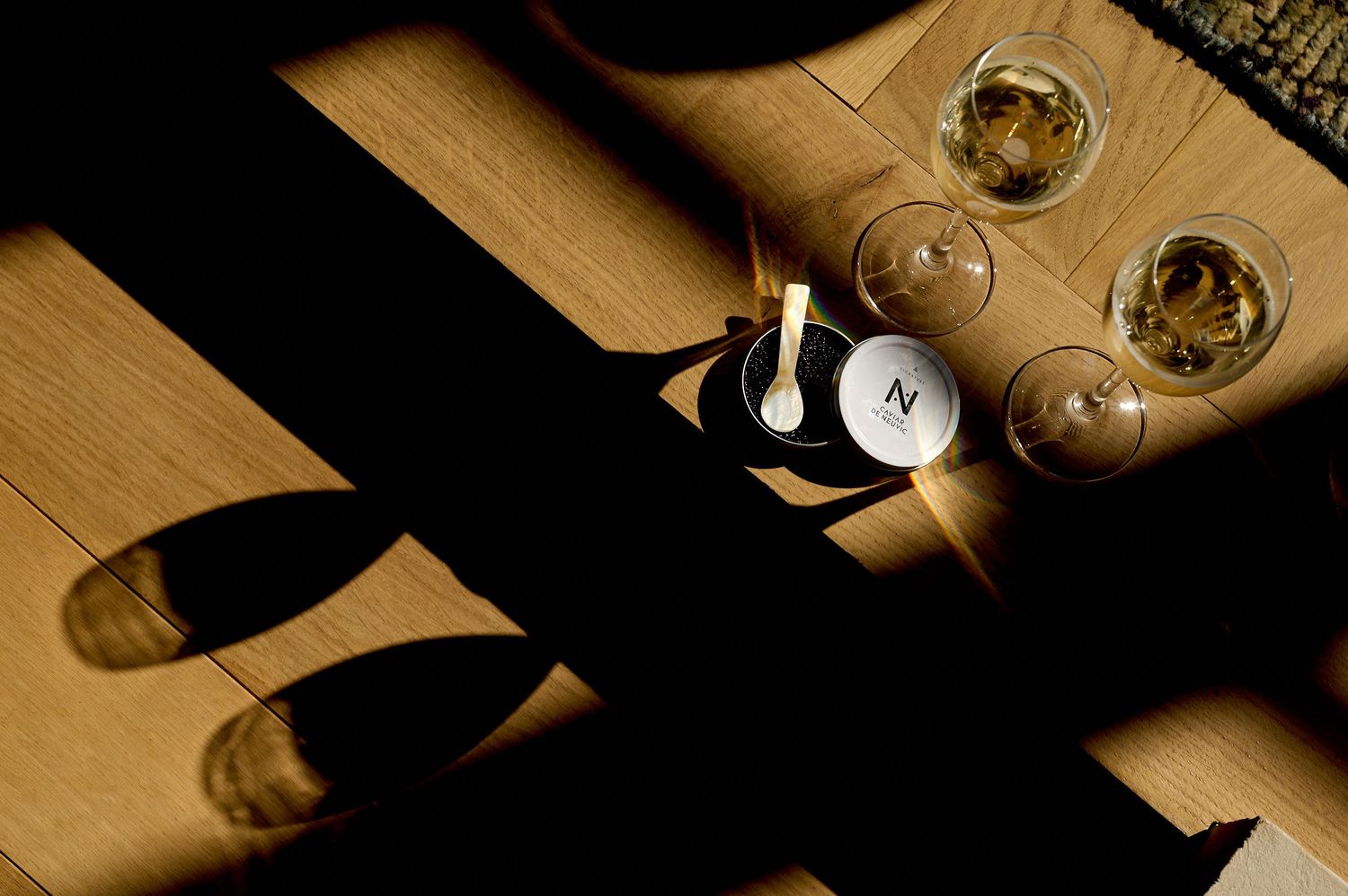 A row of elegant wine glasses on a wooden surface captured in a warm sepia tone with dramatic lighting and shadows.