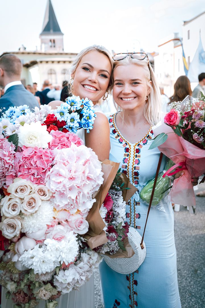 A collage of floral arrangements featuring pink, white, and blue flowers held in front of a building.