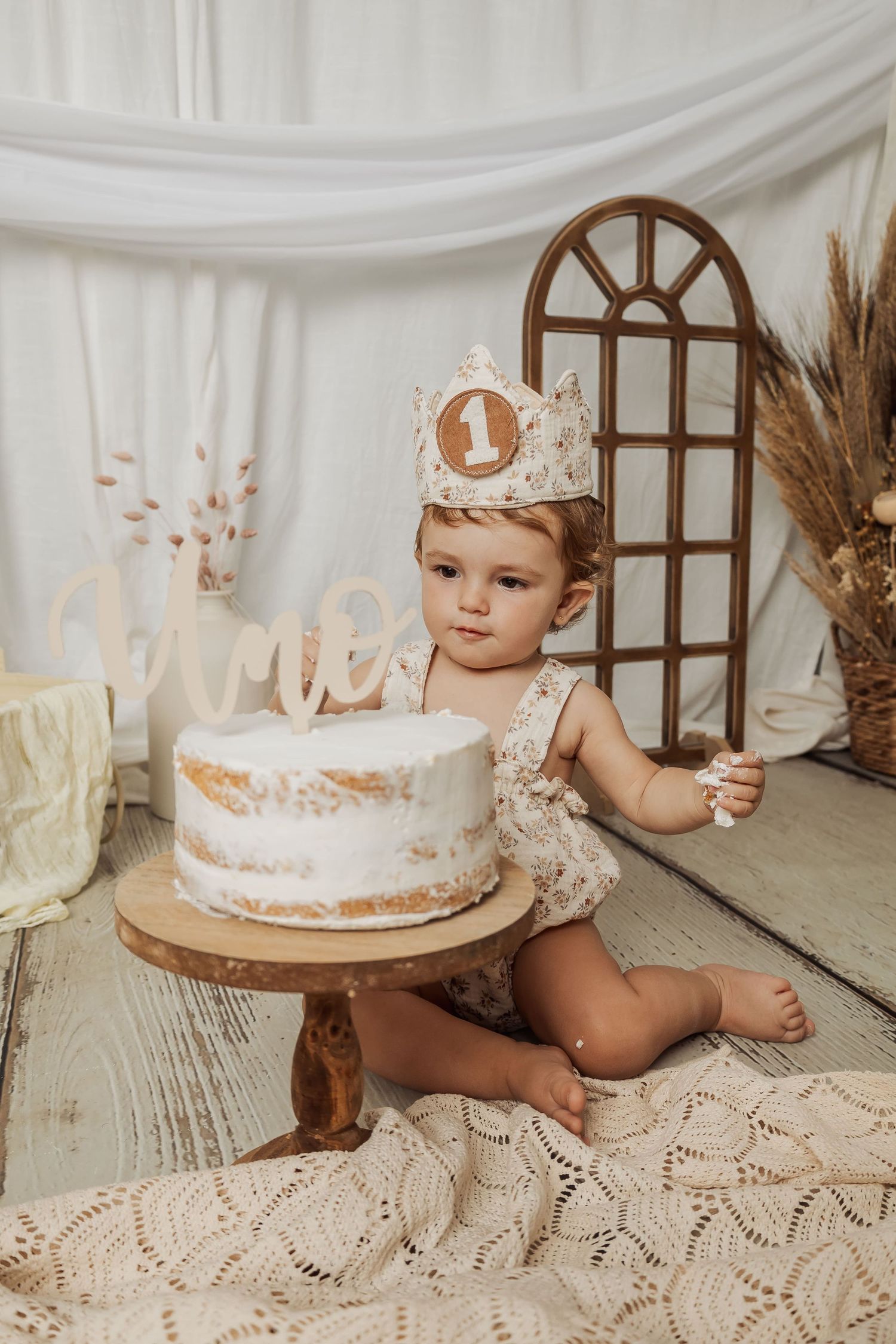 Sesión de fotos Smash Cake en Valencia niña estilo boho primer cumpleaños disfrutando de la tarta en la sesión de fotos