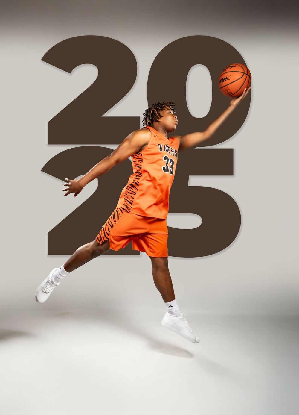 Basketball player in orange jersey leaping against grey background with large numbers.