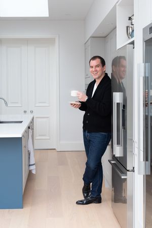 Series of photos showing a person in black sweater and jeans standing in a white modern hallway.