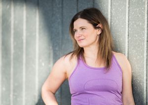 Person in purple athletic wear demonstrating different workout poses against a gray wall.