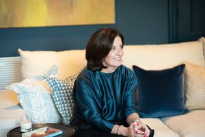 Lifestyle portrait showing a relaxed woman lounging on a modern couch with throw pillows.