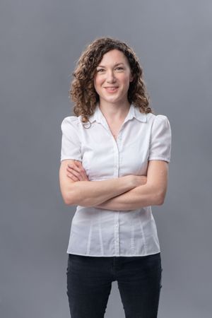Professional studio portraits showing a person in a white blouse and dark pants against a gray background.