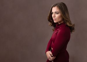A woman in a burgundy sweater poses against a dark brown backdrop in a series of professional portraits.