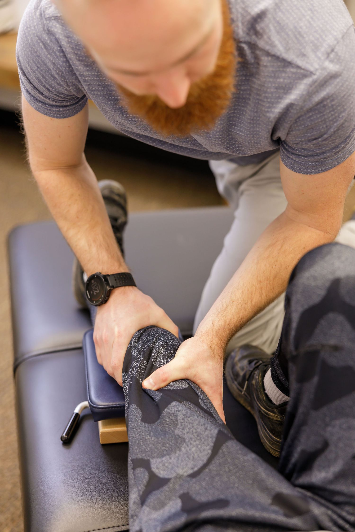 chiropractor branding photo in Sumner, WA wellness health man adjusting boy's knee using board in clinic