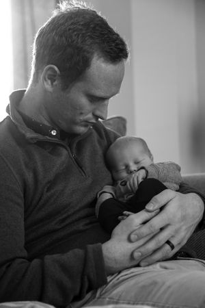 Black and white series showing tender moments between parent and sleeping infant.