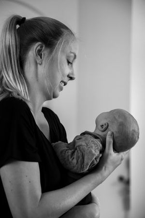 Intimate black and white portraits of mother cradling and bonding with newborn.