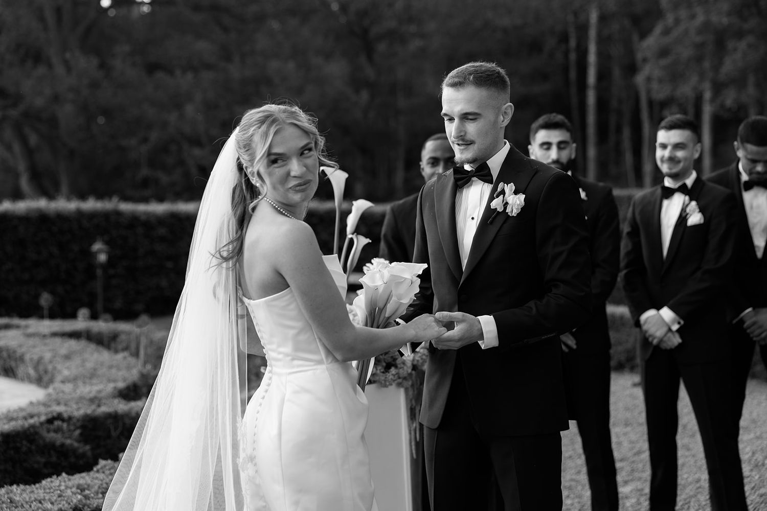 A series of black and white wedding photos showing intimate moments between a couple and their wedding party outdoors.