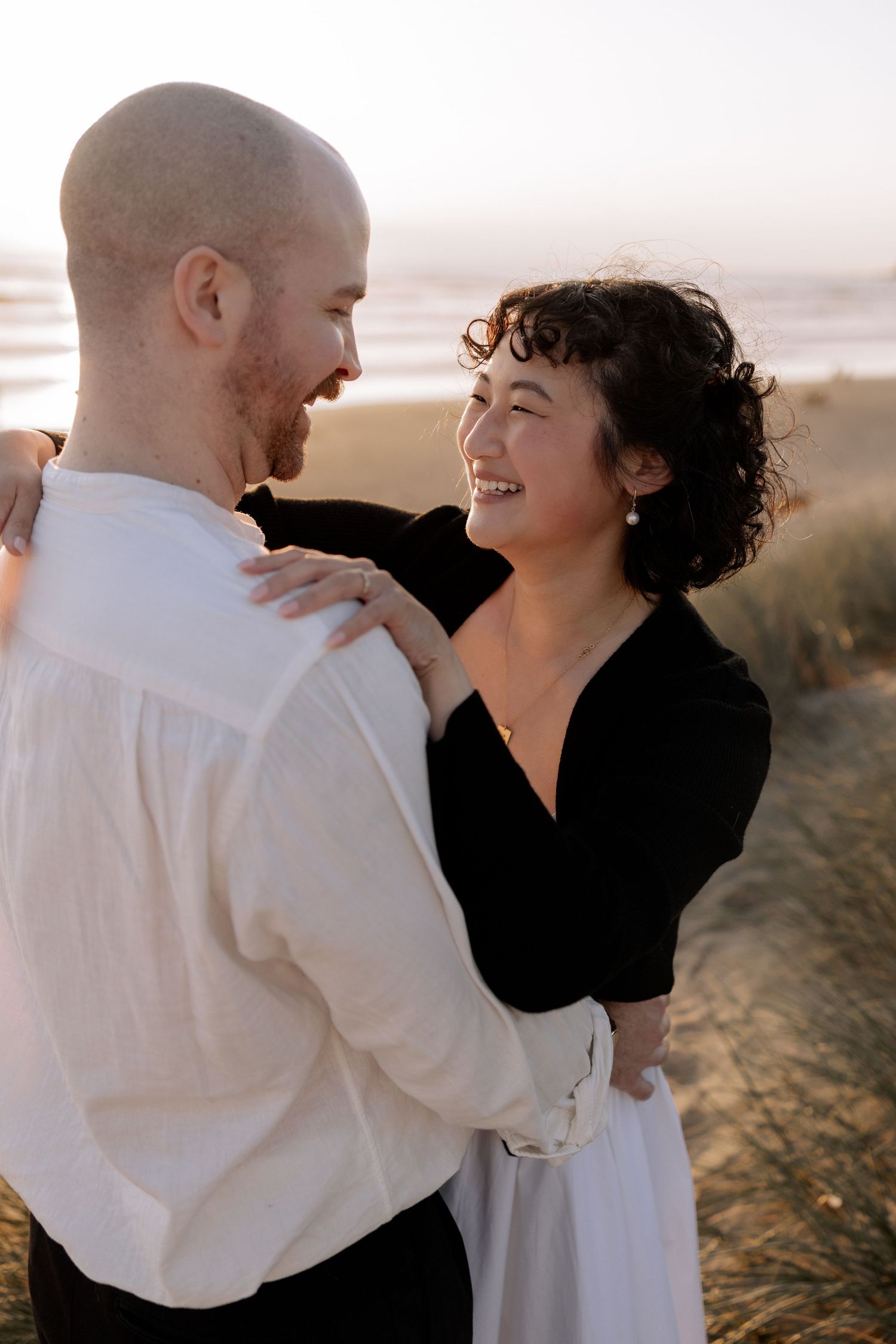 A romantic couple shares intimate moments at sunset against a natural backdrop.