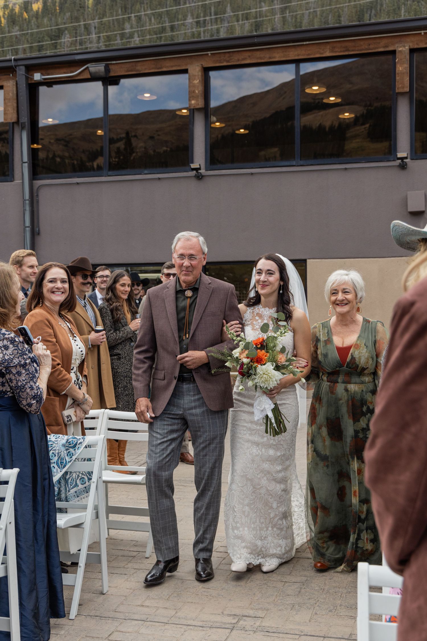 Wedding guests mingle and socialize on an outdoor patio during a reception celebration.