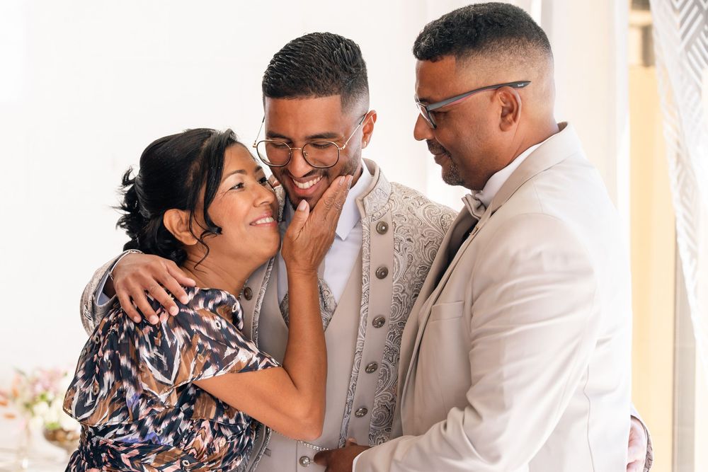 Heartwarming family moment shared between loved ones in casual attire against a light-colored background.