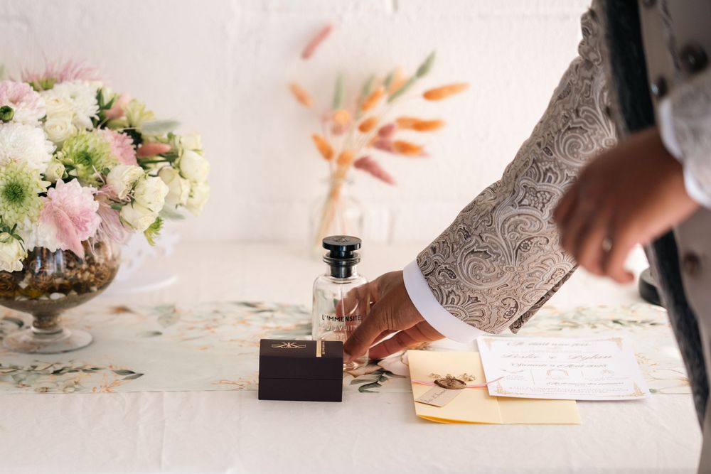 Wedding detail shots showing floral arrangements, handwritten notes and decorative elements on a white surface.