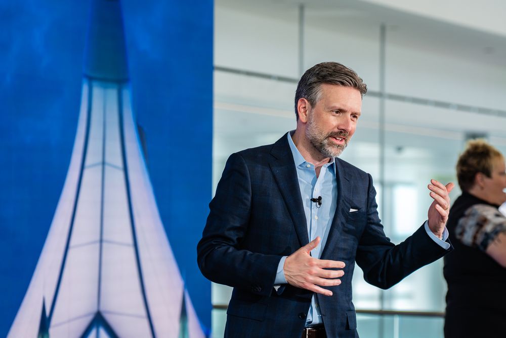 Professional speakers presenting at a corporate conference with blue lighting.
