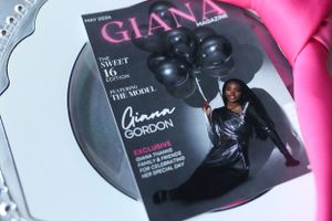 Magazine cover displayed on silver platter with pink accent décor.