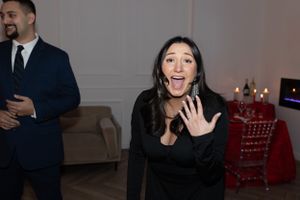 Joyful reaction shot in an elegant room with festive decorations.