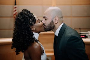 Romantic kiss shared during a courthouse wedding ceremony.